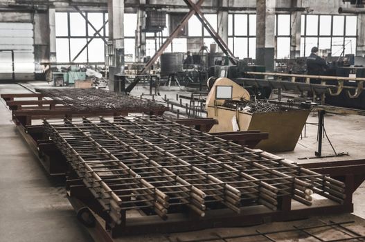 Belarus, Minsk region - March 03, 2020: Reinforcement mesh against the background of the production of concrete structures in a workshop at an industrial enterprise.