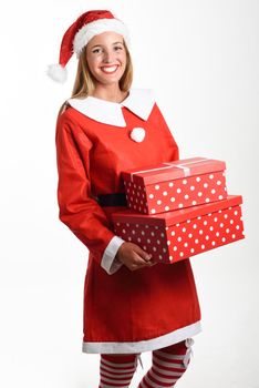Blonde woman in Santa Claus clothes smiling with gift boxes in her hands. Young female with blue eyes, isolated on white