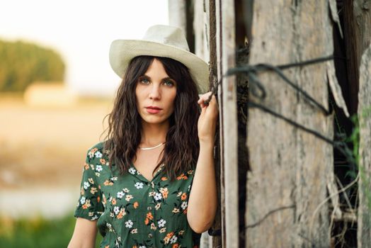 Beautiful hiker young woman, wearing flowered shirt, posing as a fashion model in the countryside.