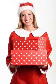 Blonde woman in Santa Claus clothes smiling with gift boxes in her hands. Young female with blue eyes and freckles in the face, isolated on white