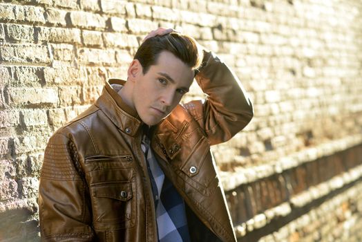 Portrait of handsome man with modern hairstyle in urban background