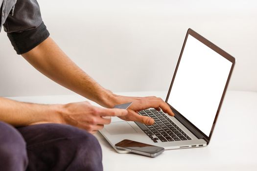 Back view of male person sitting front open laptop computer with blank empty screen for your information or content, modern businessman working in internet via notebook,student at coffee shop learning