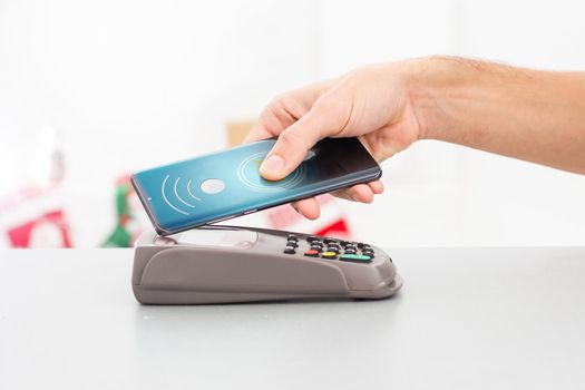 Contactless mobile payment. Payment terminal and smartphone in hands