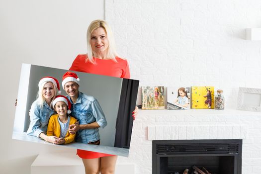 woman holding a photo canvas with a picture of christmas.