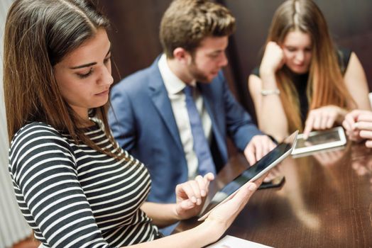 Close-up of a modern business team using tablet computer to work with financial data