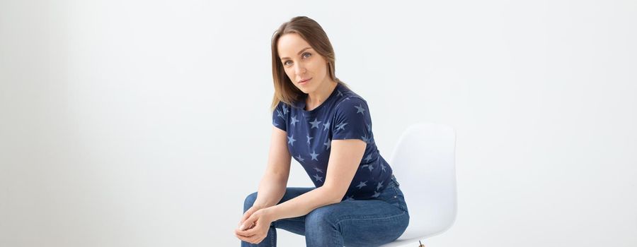 Portrait of a beautiful caucasian young woman posing against white wall background. The concept of a beautiful well-groomed woman. Copyspace