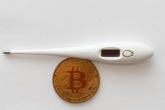 Mercury thermometer and bitcoin on white. High quality photo