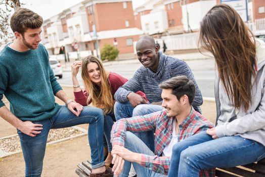 Group of multi-ethnic young people having fun together outdoors in urban background