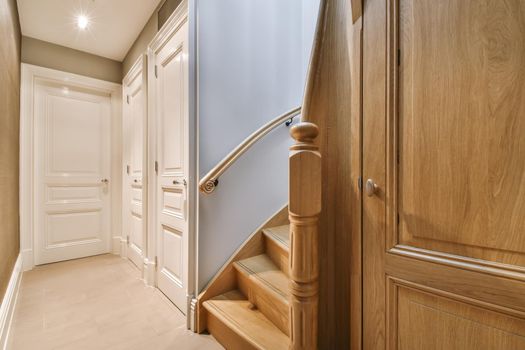 Corridor with a wooden staircase and three doors