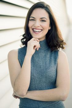 Beautiful young woman, model of fashion, smiling in urban background