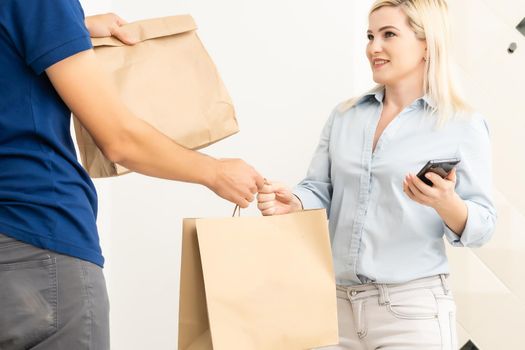 Smiling delivery man giving boxes to woman customer at home for online shopping service concept