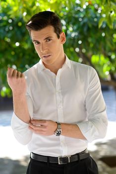 Portrait of handsome man with modern hairstyle in urban background