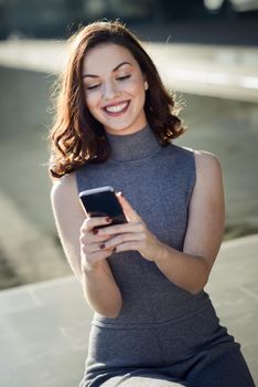 Beautiful young woman with a smartphone in an office building