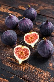 Purple figs on a wooden table. Dark wooden background. Top view.