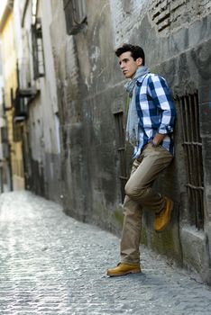 Portrait of handsome man with modern hairstyle in urban background