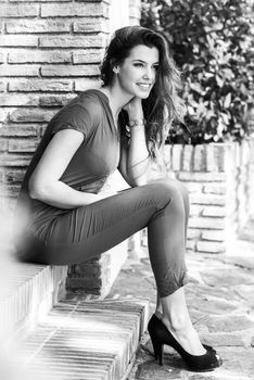 Portrait of beautiful woman smiling, wearing casual clothes sitting in step