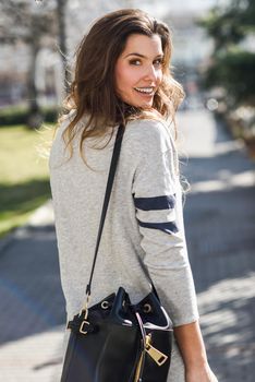 Portrait of beautiful woman smiling, wearing casual clothes in urban background