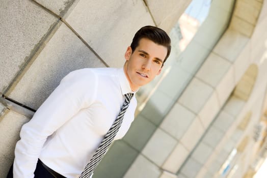 Portrait of attractive young businessman in urban background