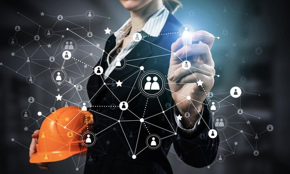 Businesswoman pointing on abstract 3d network. Back view of woman engineer in business suit and safety helmet. Social connection and networking. Futuristic technology concept with 3d plexus structure.