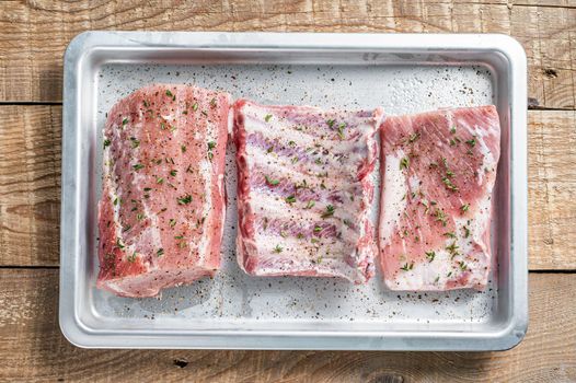 Set of Raw pork cuts, loin meat, spare ribs and brisket. Wooden background. Top view.