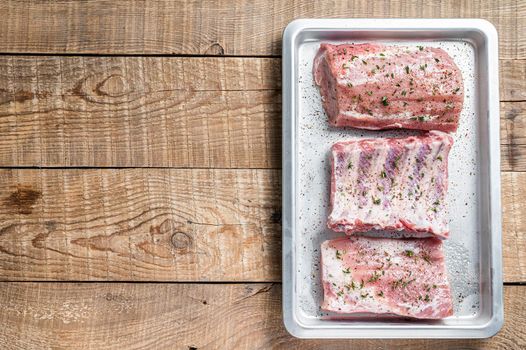 Set of Raw pork cuts, loin meat, spare ribs and brisket. Wooden background. Top view. Copy space.