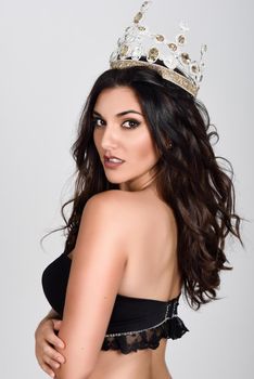 Crowned woman like miss of beauty looking at camera isolated on white background. Girl wearing crown, studio shot.