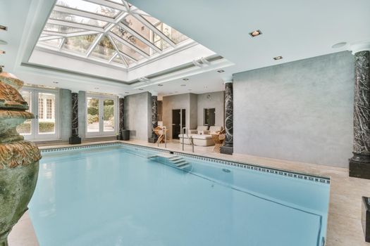 Large beautiful indoor swimming pool with glass ceiling