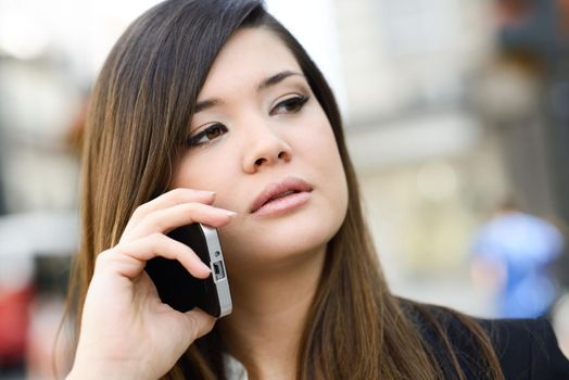 Portrait of japanese business woman in urban background on the phone