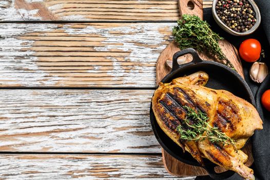 Baked whole farm chicken with thyme. White background. Top view. Copy space.