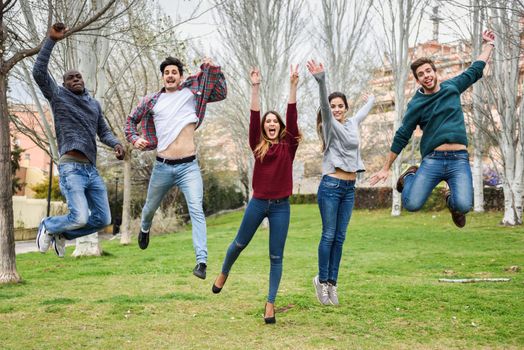 Group of multi-ethnic young people jumping together outdoors