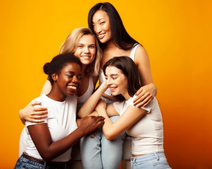 diverse multi nation girls group, teenage friends company cheerful having fun, happy smiling, cute posing on yellow background, lifestyle people concept, african-american, asian and caucasian close up