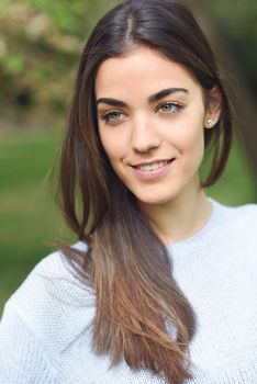 Portrait of young woman smiling in urban background wearing casual clothes