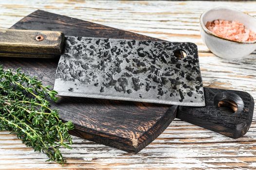 Old meat butcher cleaver. White wooden background. Top view.