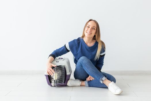 Positive good-looking woman and beautiful gray Scottish Fold cat into her new apartment after the move. Housewarming and pets concept