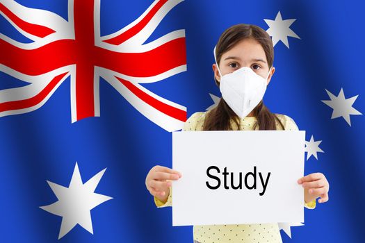 little girl in medical mask with the inscription COVID-19 on a blurred background of the flag of Australia. Pandemic virus COVID-19. Healthcare and medical concept.