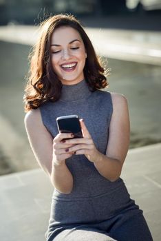 Beautiful young woman with a smartphone in an office building