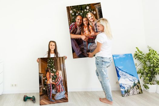 woman holding photo canvas on the background of a interior.