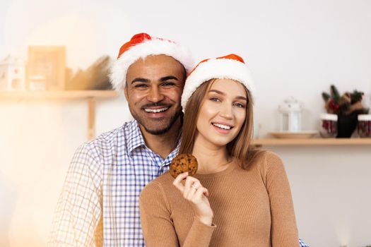 Cheerful attractive happy couple in Santa hats, close up portrait