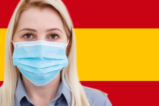 Masked woman face looking at the camera on flag Spain background. The concept of attention to the worldwide spread of the coronavirus worldwide. Coronavirus, virus in Spain.