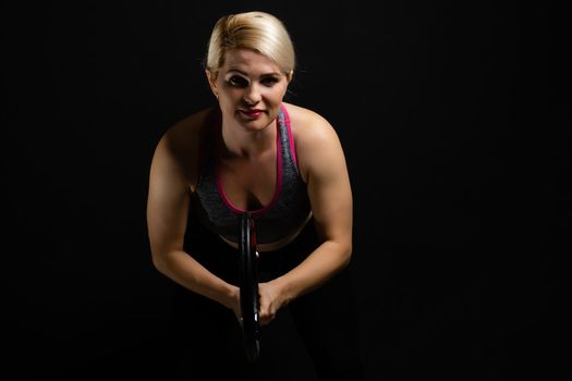 Female tennis player with racket and ball on black background