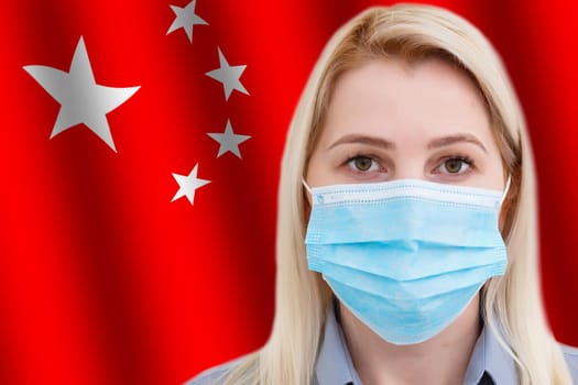 Young woman in medical protective mask on background of China flag with inscription 2019-nCov, Coronavirus.