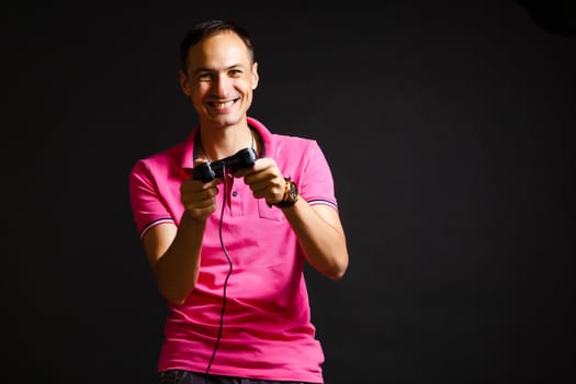 a man plays with a joystick at home on a black background