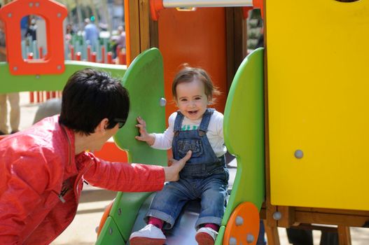 Happy little girl playing in a urban playground.