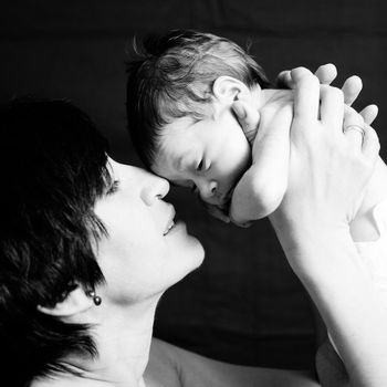 Studio portrait in black and white of happy mother with baby girl