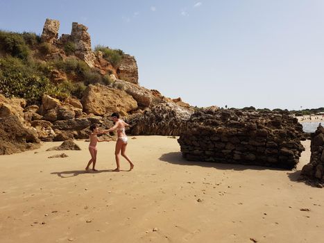 Mother and little daughter having fun on the beach of the Wall of Puerto Sherry, in Puerto de Santa Mar a, C diz, Andalusia, Spain.