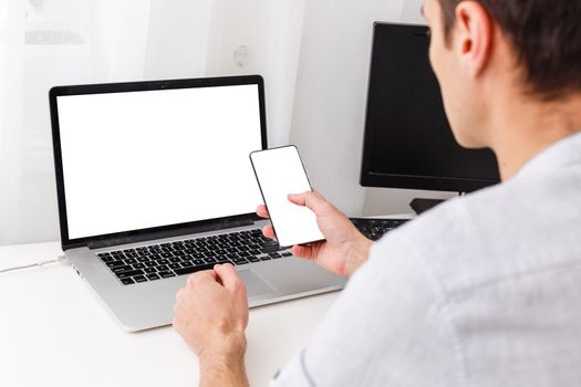 Back view of male person sitting front open laptop computer with blank empty screen for your information or content, modern businessman working in internet