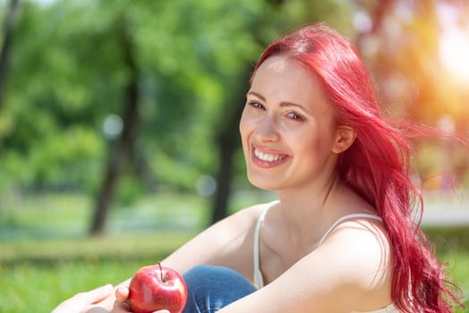 Portrait of a young attractive woman in the park. Smiling and happy