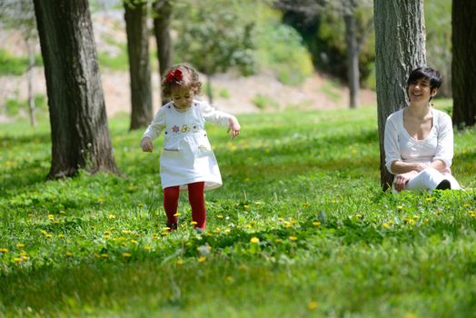 Portrait of mother and little girl playing in the park