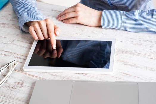 Business lady sitting at desk with tablet computer. Corporate office workplace with laptop. Mobile smart device in business processes. Business occupation concept with business woman at wooden desk.