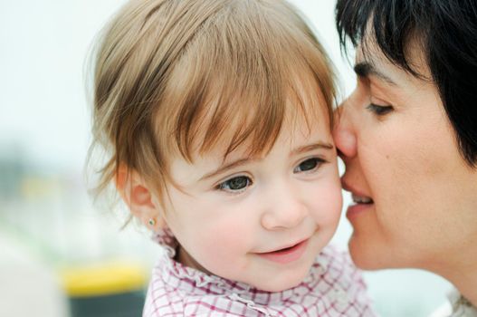 Beautiful woman and her cute little daughter are hugging